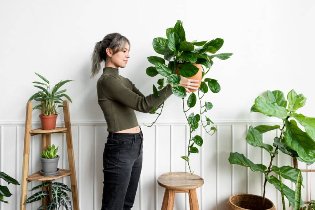 happy woman carrying houseplant