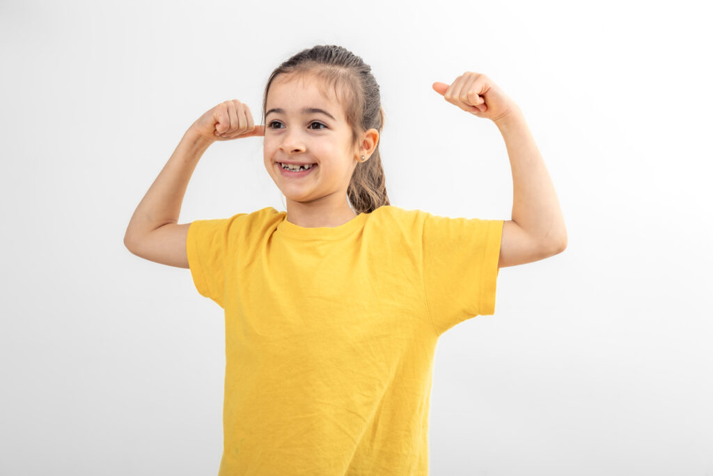 little girl hand flexing demonstrating biceps isolated white background